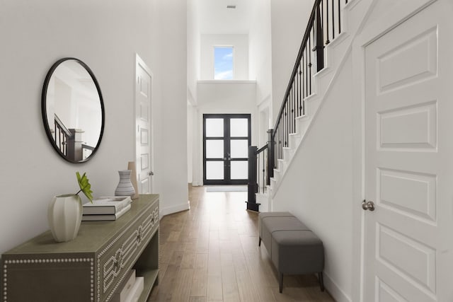 entrance foyer with hardwood / wood-style flooring, a high ceiling, and french doors