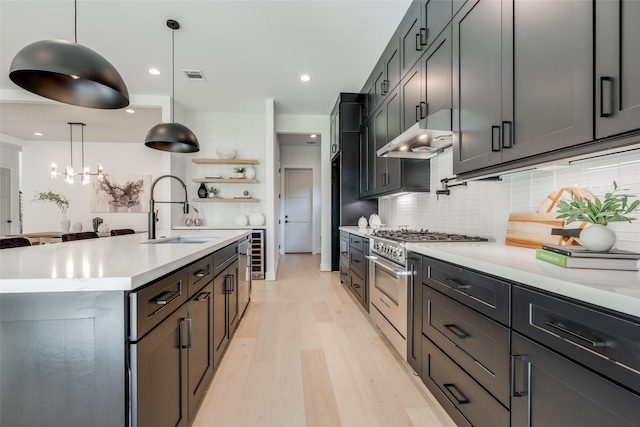 310 E 27th St, Houston, TX 77008 - kitchen featuring light wood finished floors, a sink, visible vents, high end stove, and backsplash