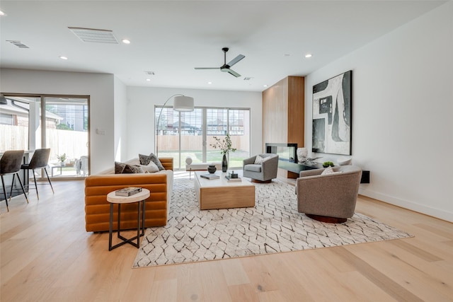 310 E 27th St, Houston, TX 77008 - living room featuring light wood-style floors, visible vents, ceiling fan, and a healthy amount of sunlight