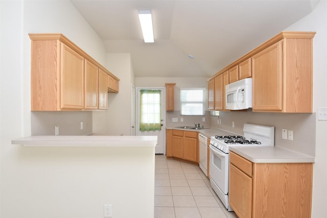 kitchen featuring light tile patterned flooring, sink, vaulted ceiling, light brown cabinets, and white appliances