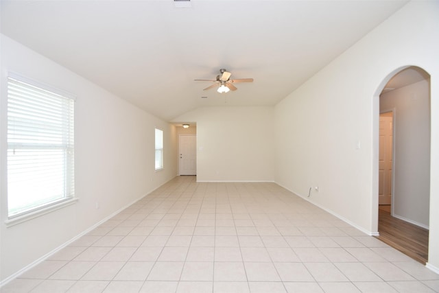 tiled empty room featuring vaulted ceiling and ceiling fan