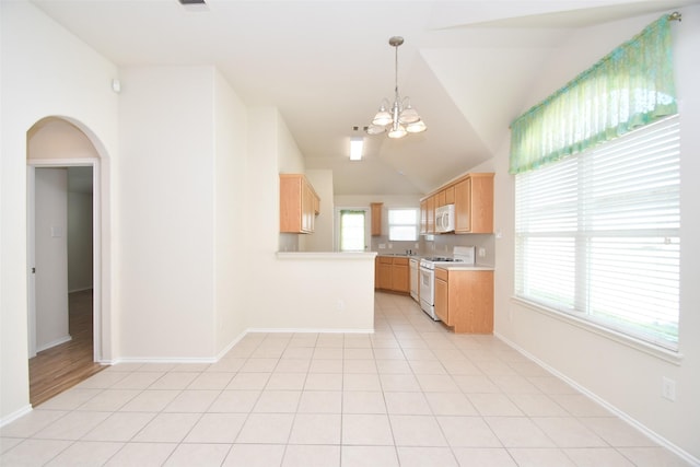 kitchen featuring light tile patterned flooring, lofted ceiling, light brown cabinets, a notable chandelier, and white appliances