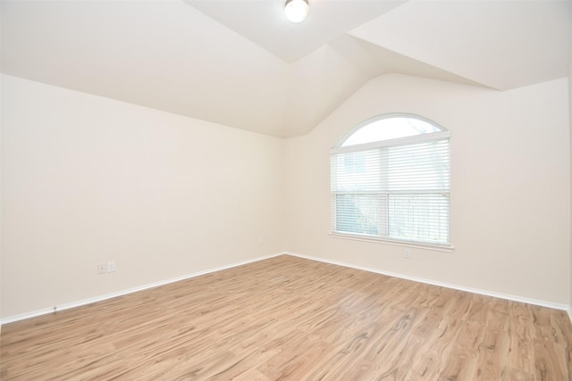 unfurnished room with lofted ceiling and light hardwood / wood-style floors