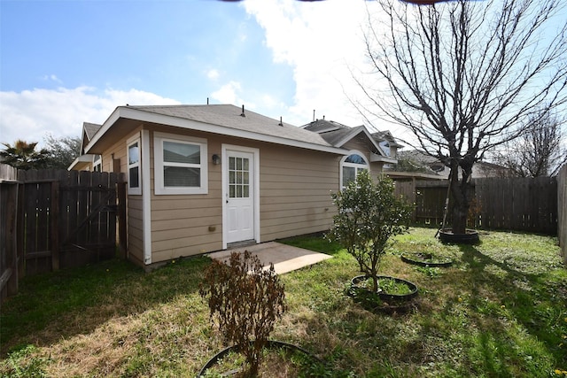 rear view of property featuring a lawn