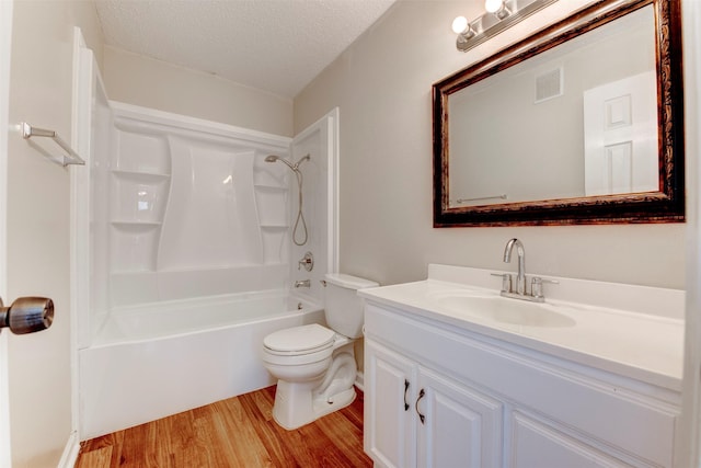 full bathroom featuring hardwood / wood-style floors, vanity, toilet, a textured ceiling, and washtub / shower combination