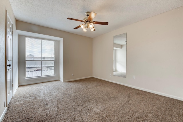 carpeted empty room with ceiling fan and a textured ceiling