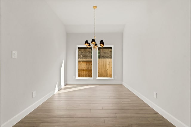 unfurnished dining area featuring hardwood / wood-style floors and an inviting chandelier