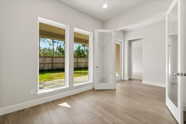 unfurnished room with light hardwood / wood-style floors and french doors