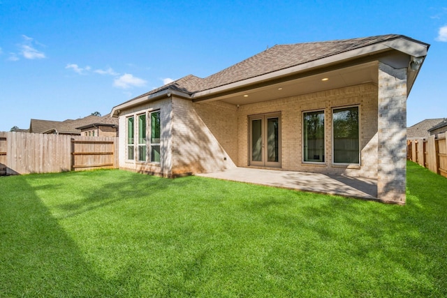 rear view of property featuring a yard and a patio area