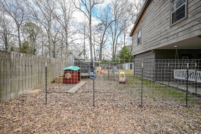 view of yard with a playground and a trampoline