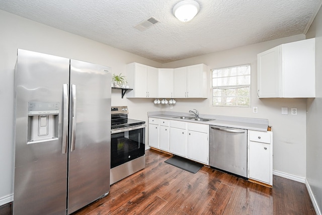 kitchen with sink, white cabinetry, a textured ceiling, dark hardwood / wood-style floors, and stainless steel appliances