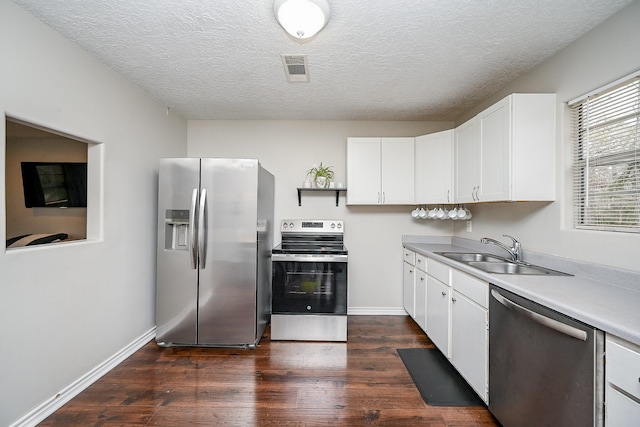 kitchen with stainless steel appliances, sink, white cabinets, and dark hardwood / wood-style floors