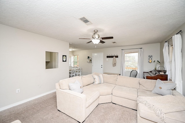 carpeted living room with a textured ceiling and ceiling fan