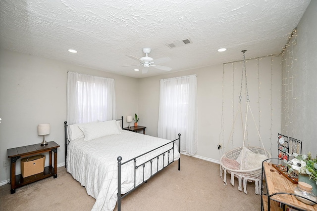 carpeted bedroom with a textured ceiling and ceiling fan