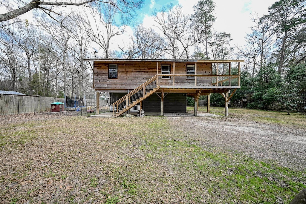 rear view of property with a deck and a lawn