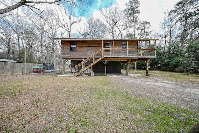 rear view of property with a deck and a lawn