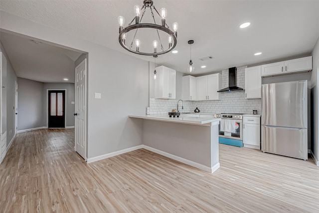 kitchen with tasteful backsplash, visible vents, light wood finished floors, wall chimney range hood, and appliances with stainless steel finishes