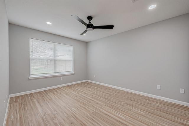 spare room featuring recessed lighting, a ceiling fan, light wood-style floors, and baseboards