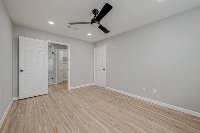 unfurnished bedroom featuring light wood finished floors, visible vents, a walk in closet, ceiling fan, and baseboards