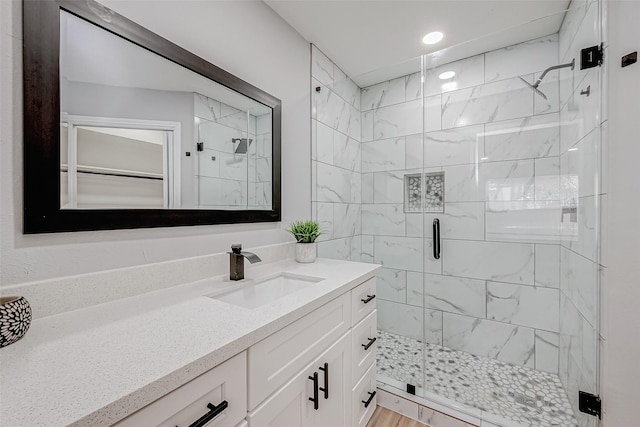 full bathroom with vanity, a shower stall, and recessed lighting