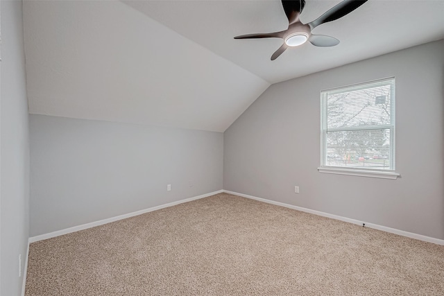 bonus room featuring lofted ceiling, carpet flooring, a ceiling fan, and baseboards