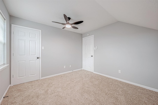 unfurnished bedroom featuring vaulted ceiling, carpet flooring, baseboards, and ceiling fan