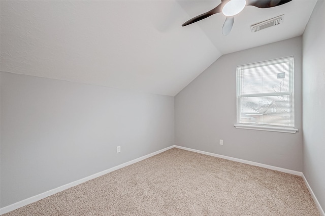 additional living space with visible vents, a ceiling fan, carpet, baseboards, and vaulted ceiling