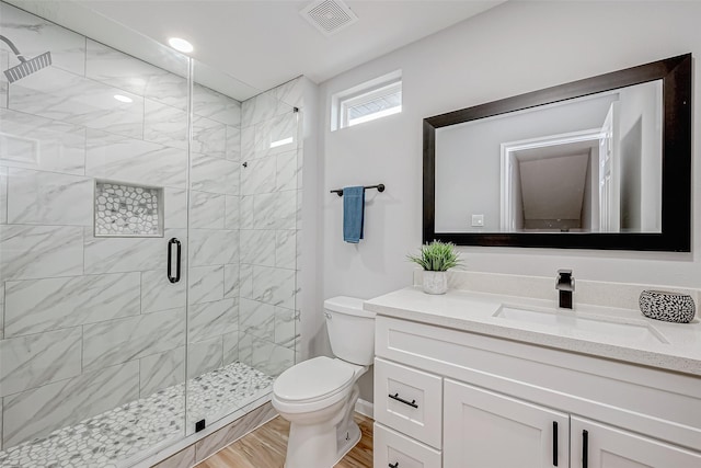 bathroom featuring vanity, a shower with shower door, wood-type flooring, and toilet