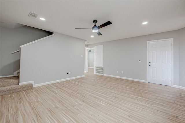 unfurnished living room with visible vents, baseboards, light wood-style floors, and stairway