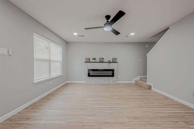 unfurnished living room featuring visible vents, a fireplace, stairs, and wood finished floors