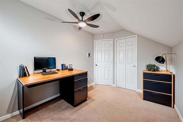 home office with vaulted ceiling, a ceiling fan, baseboards, and light carpet