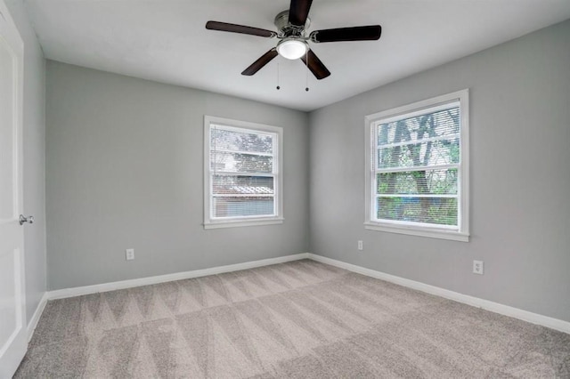 carpeted empty room featuring ceiling fan and plenty of natural light