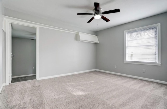 empty room featuring ceiling fan and carpet