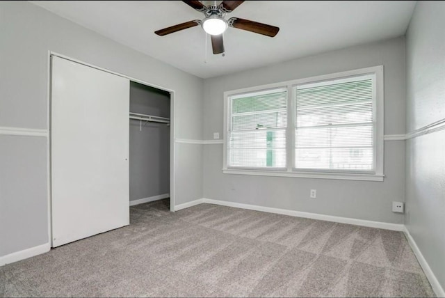 unfurnished bedroom featuring ceiling fan, light colored carpet, and a closet