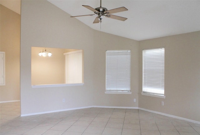 empty room with high vaulted ceiling, a healthy amount of sunlight, ceiling fan with notable chandelier, and light tile patterned floors