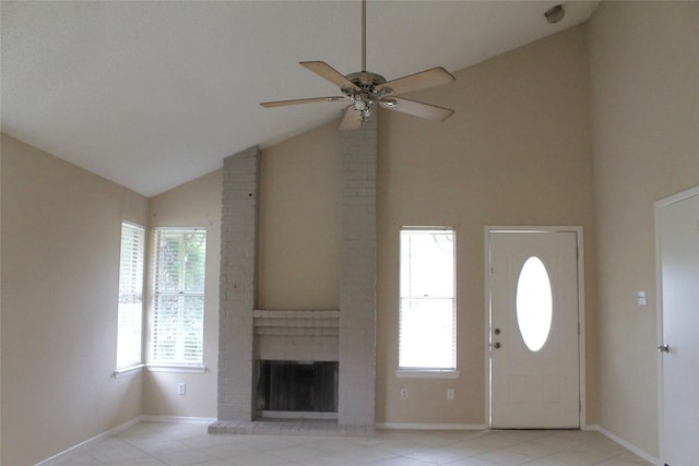 foyer entrance featuring ceiling fan, high vaulted ceiling, and a brick fireplace