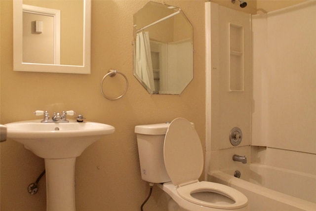 full bathroom featuring sink, shower / tub combo with curtain, and toilet