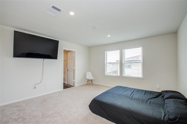 bedroom featuring ensuite bathroom and carpet