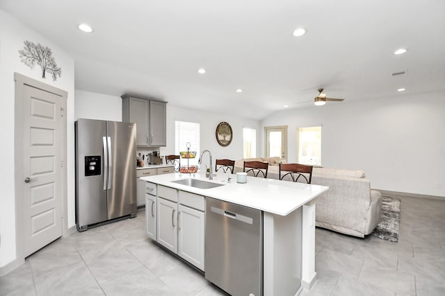 kitchen featuring sink, a center island with sink, gray cabinets, ceiling fan, and stainless steel appliances