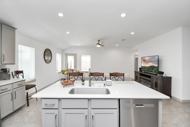 kitchen featuring gray cabinets, a wealth of natural light, dishwasher, sink, and a kitchen island with sink