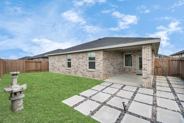 rear view of property featuring a yard and a patio area