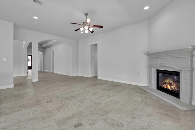 unfurnished living room with a premium fireplace and ceiling fan