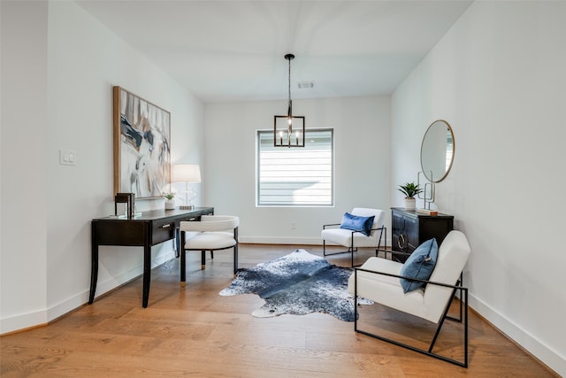 living area with hardwood / wood-style flooring and an inviting chandelier