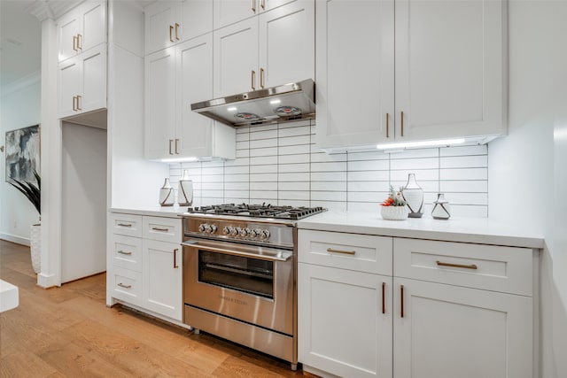 kitchen featuring tasteful backsplash, high end range, light wood-type flooring, and white cabinets