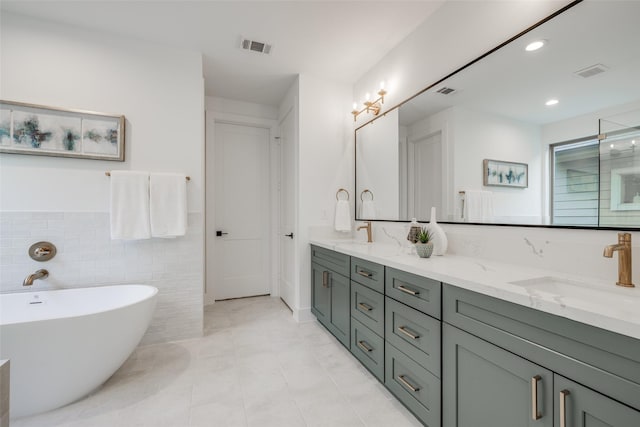 bathroom with a bathing tub, tile walls, vanity, and tile patterned floors