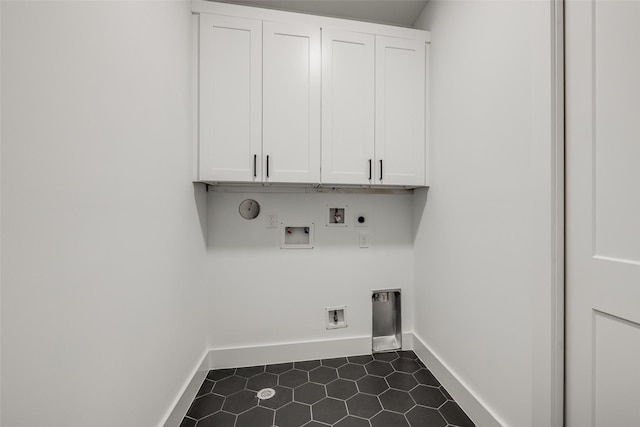 laundry room featuring gas dryer hookup, cabinets, dark tile patterned floors, hookup for a washing machine, and hookup for an electric dryer