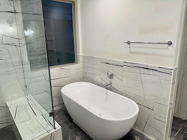 bathroom with a tub and tile walls