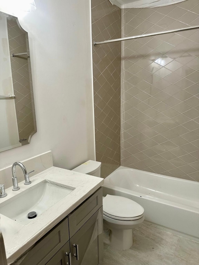 full bathroom with tiled shower / bath combo, vanity, and toilet