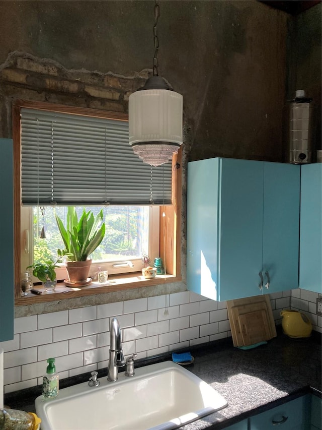 kitchen featuring sink, backsplash, and blue cabinetry