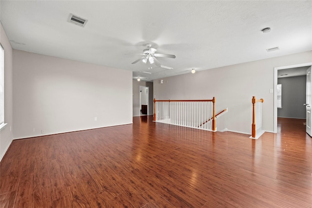 unfurnished room with visible vents, ceiling fan, baseboards, and wood finished floors